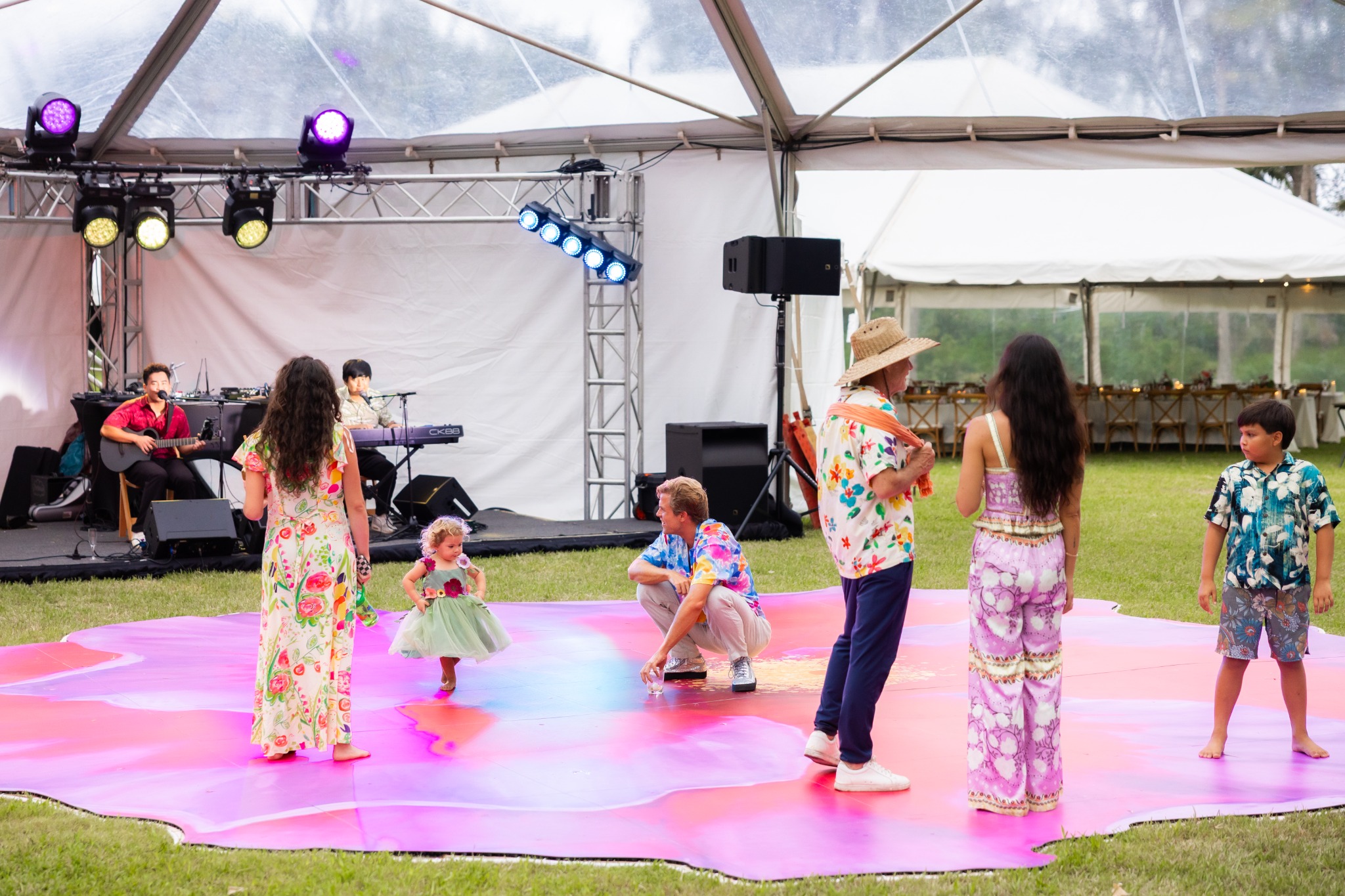 Adults and children enjoying the hibiscus dance floor in front of a live band