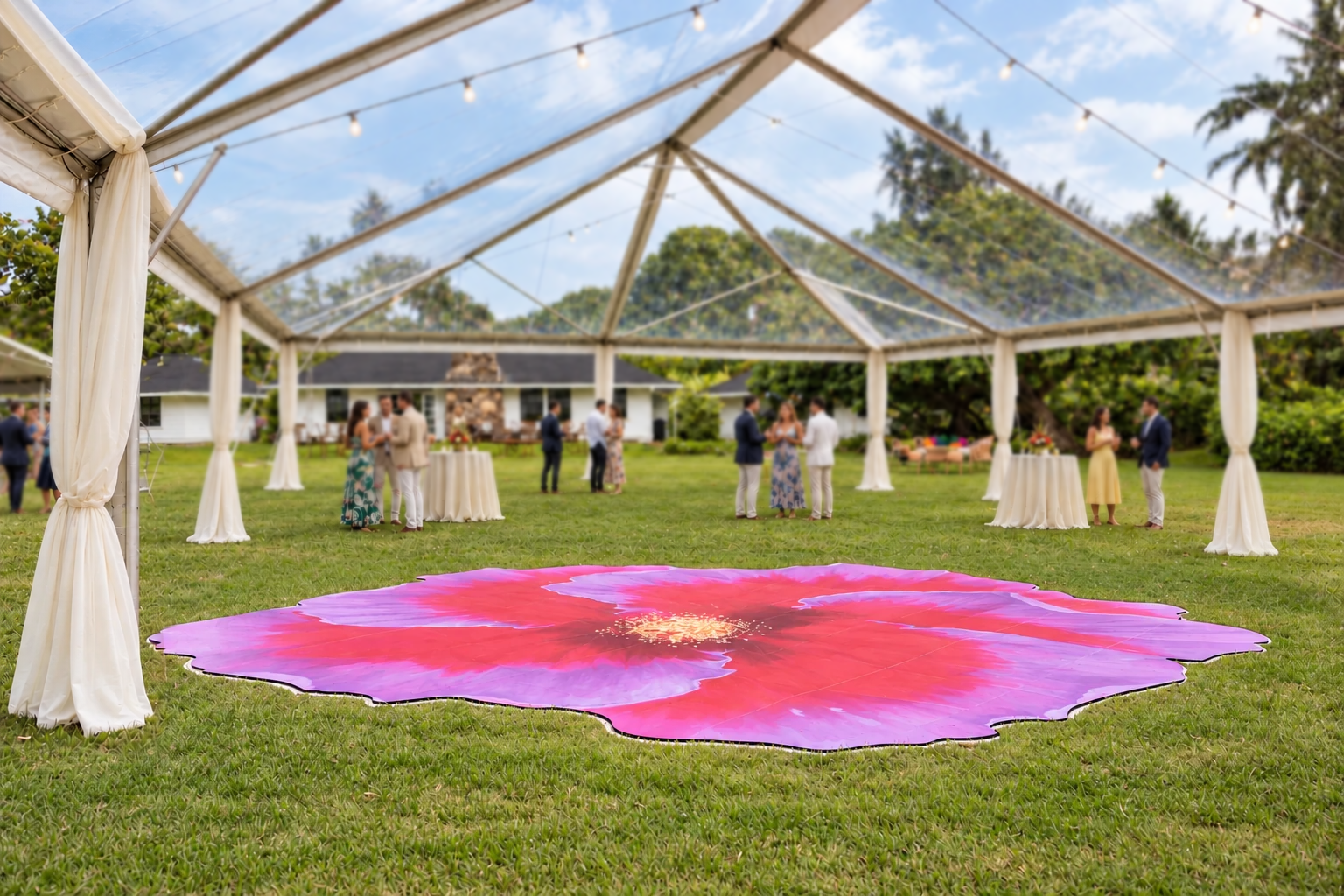 The full pink and lavender hibiscus dance floor beneath a clear event tent